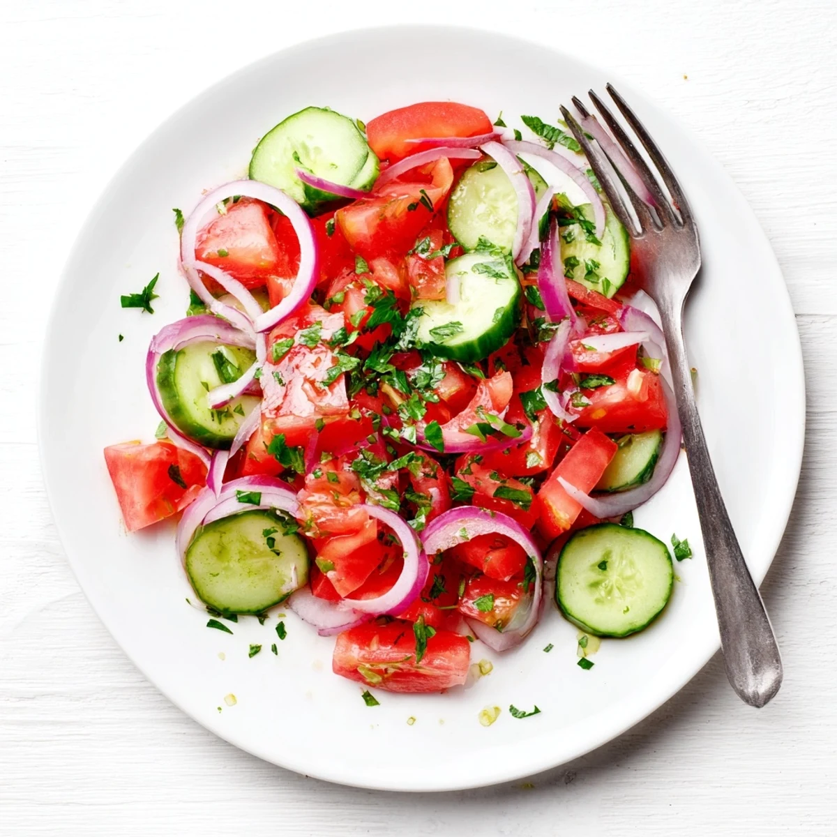 Fresh tomato cucumber onion salad with vibrant red and green vegetables tossed in light vinaigrette