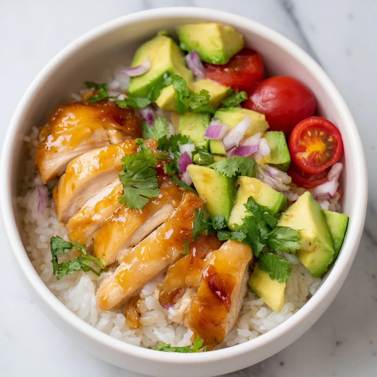 Sliced honey lime glazed chicken served over steaming rice with buttery avocado and zesty lime wedges
