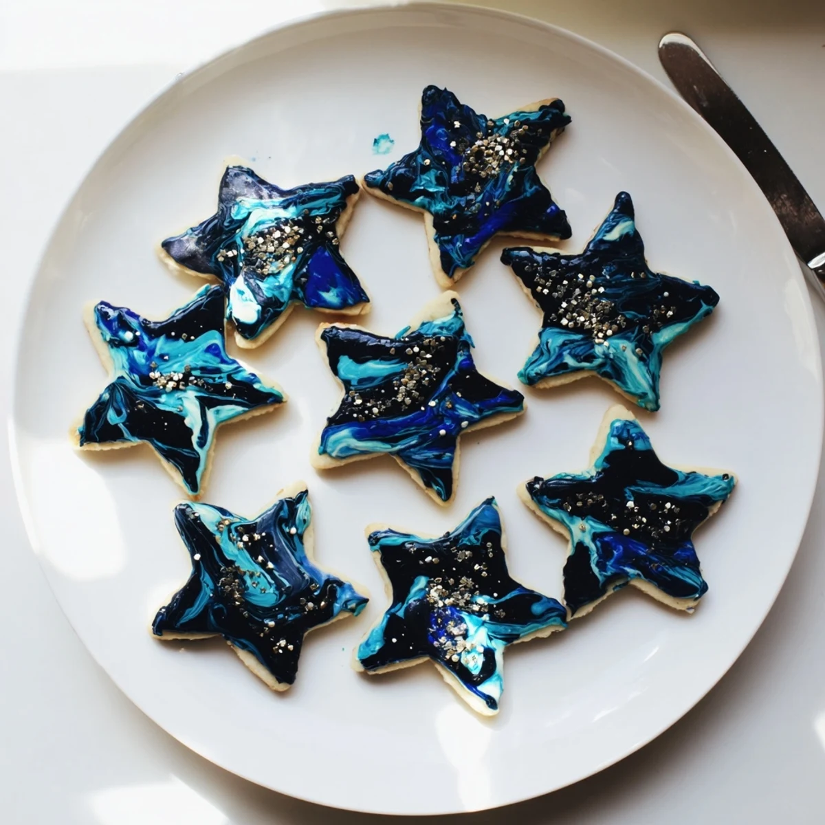 Starry Night Sugar Cookies featuring deep blue marbled icing topped with shimmering edible gold stars