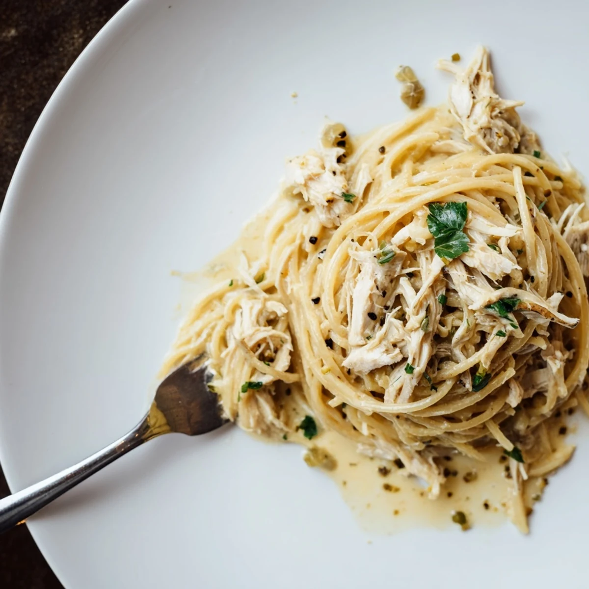 Slow cooker Angel Chicken with rich cream cheese sauce draped over pasta strands