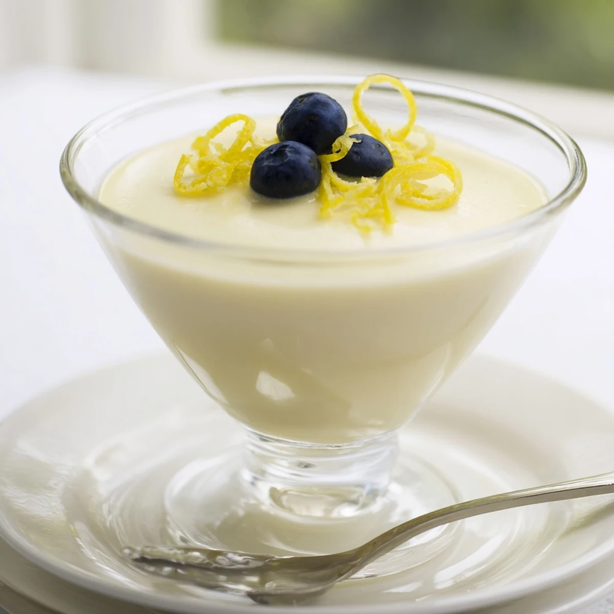 Rich British lemon posset set to perfection with vibrant yellow color and smooth texture