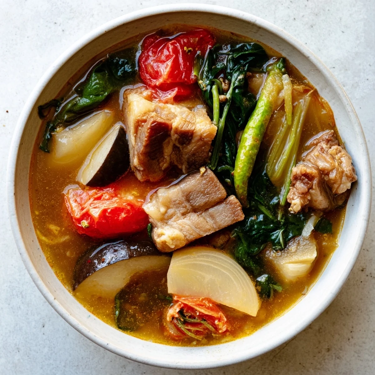 Filipino Sinigang sour soup featuring vibrant vegetables in a tangy tamarind broth
