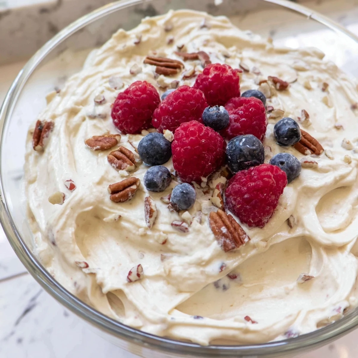 Creamy keto cheesecake fluff piled high in a glass topped with fresh berries