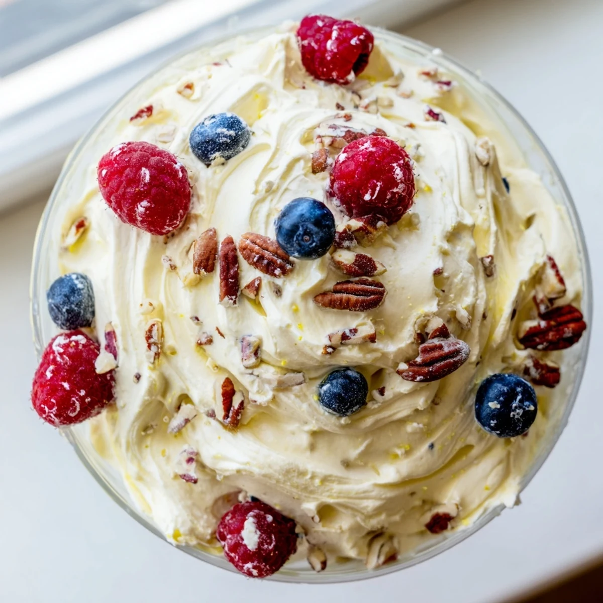 Light and airy keto cheesecake fluff swirled with vanilla and crowned with raspberries