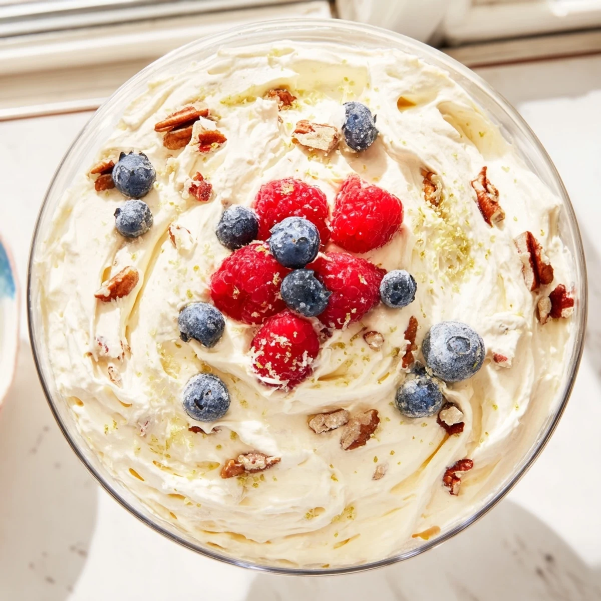 Smooth keto cheesecake fluff spooned into dessert cups and garnished with chopped pecans