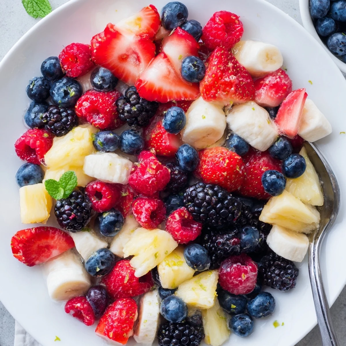 Chilled Red White And Blue Fruit Salad tossed gently with honey and lime dressing.
