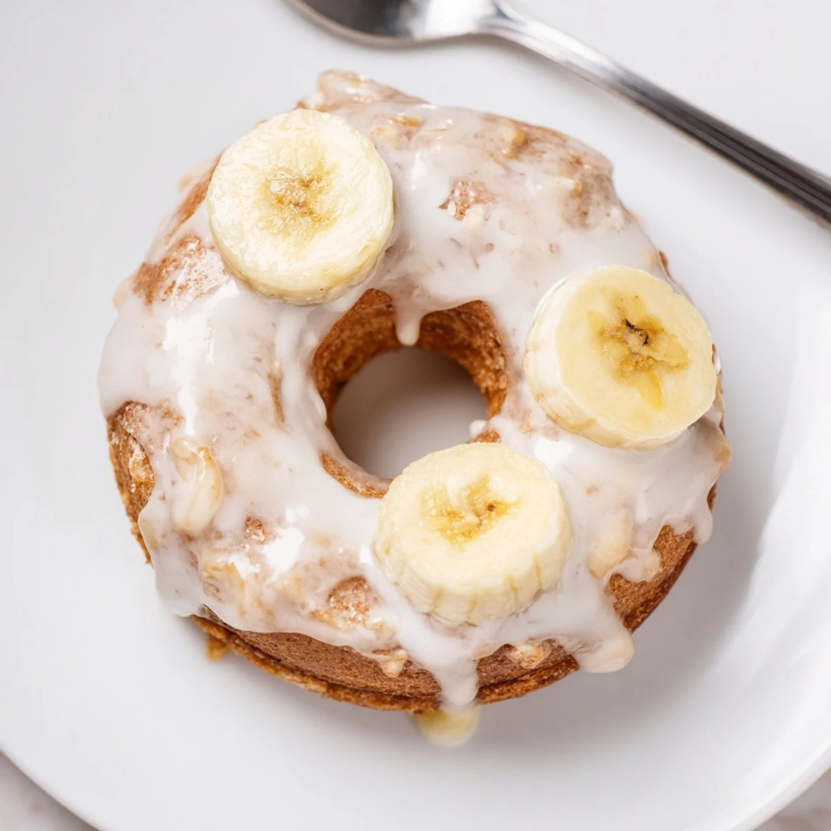Baked Banana Donuts plated with glaze drizzle and optional chocolate chips