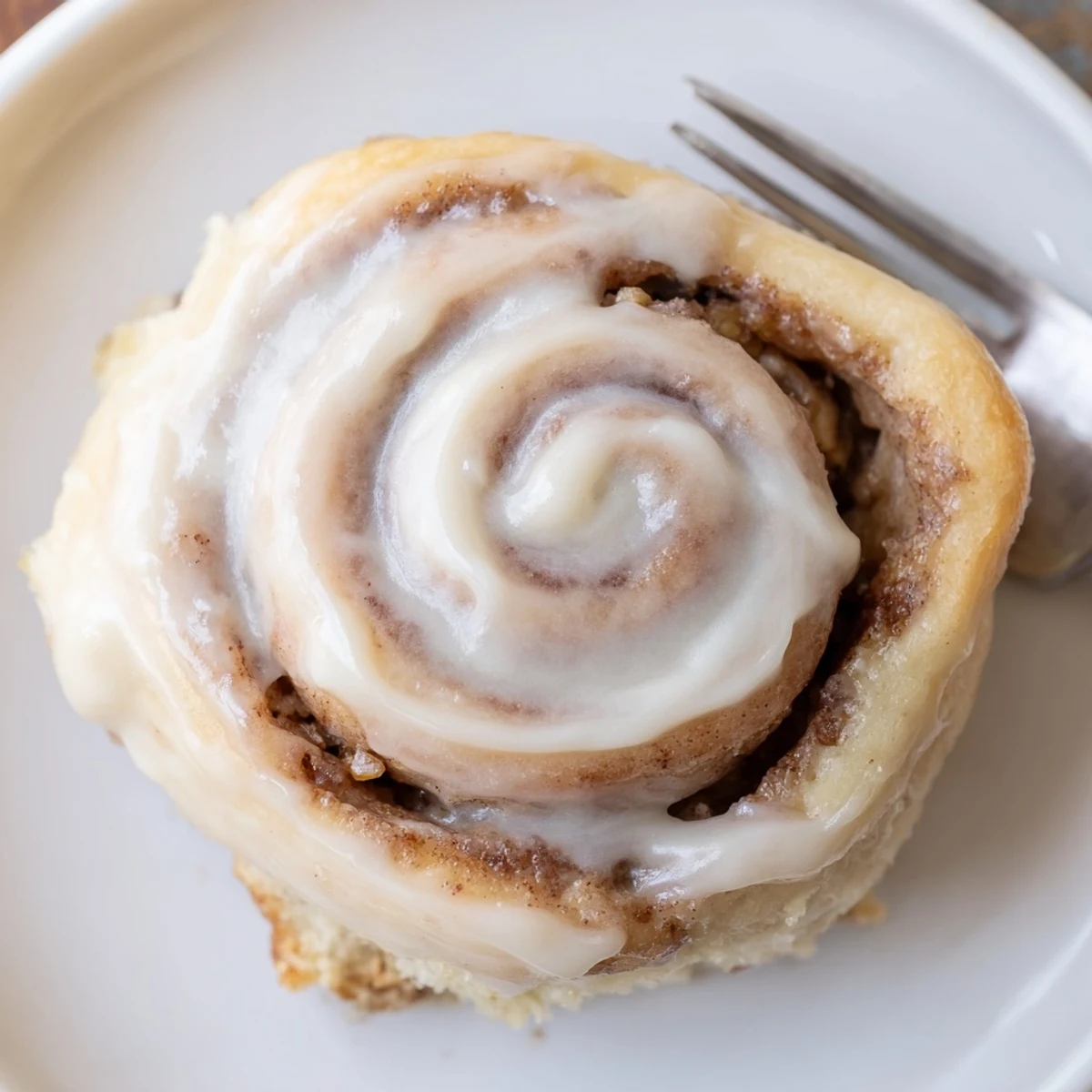 Steaming Banana Bread Cinnamon Rolls topped with cream cheese icing, warm aroma