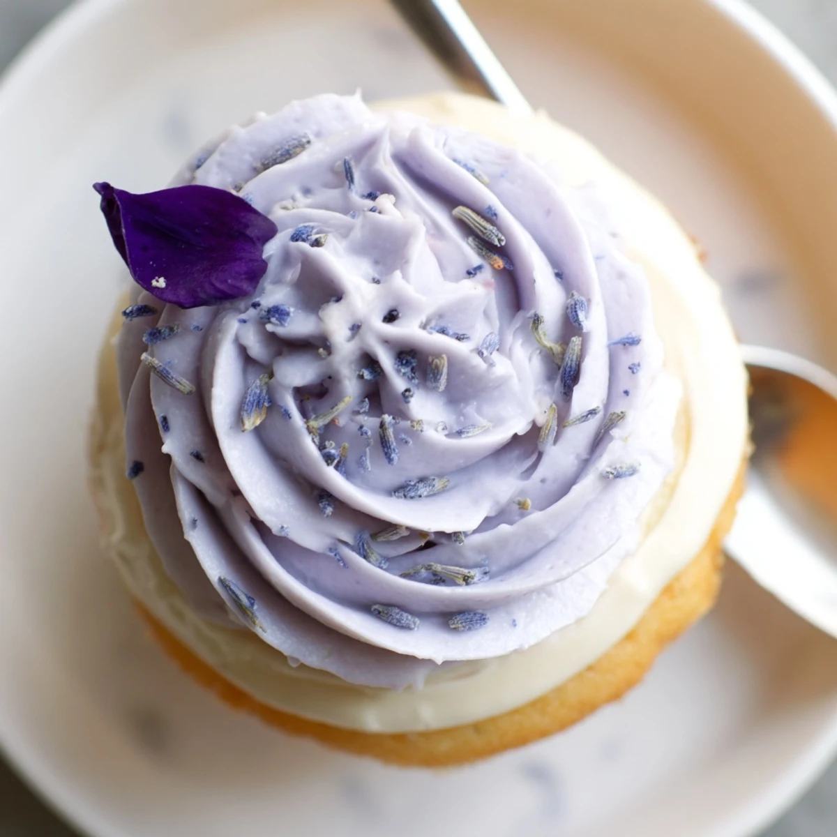 Close up of Lavender Buttercream Floral Frosting swirls with edible violet garnish