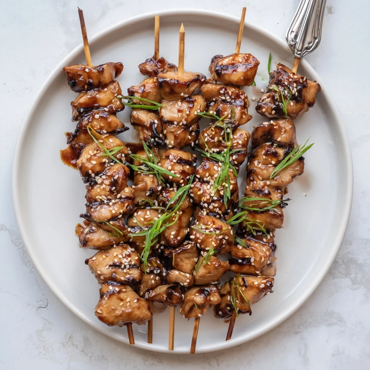 Teriyaki Chicken Skewers glistening with sticky glaze, grilled, sprinkled with sesame