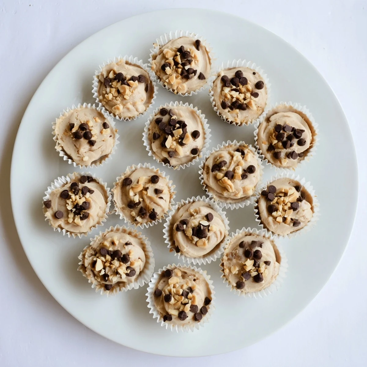 Homemade high protein peanut butter Greek yogurt bites displayed in a silicone mold with crunchy peanut and chocolate toppings