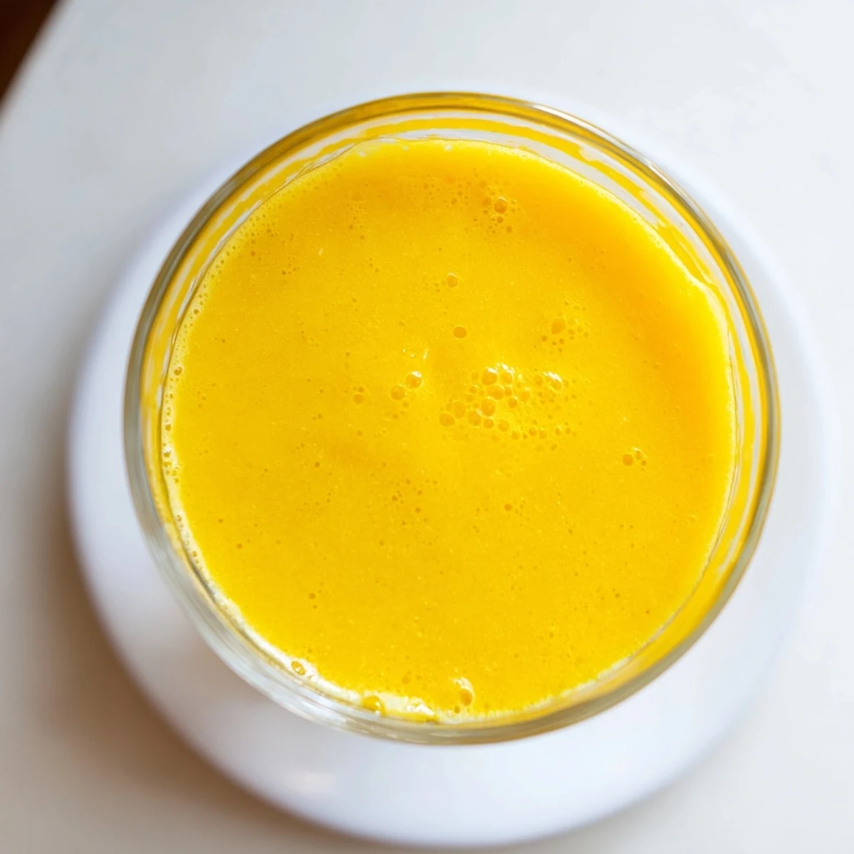Creamy blended Tropical Pineapple Mango Smoothie Recipe poured into two tall glasses with garnish