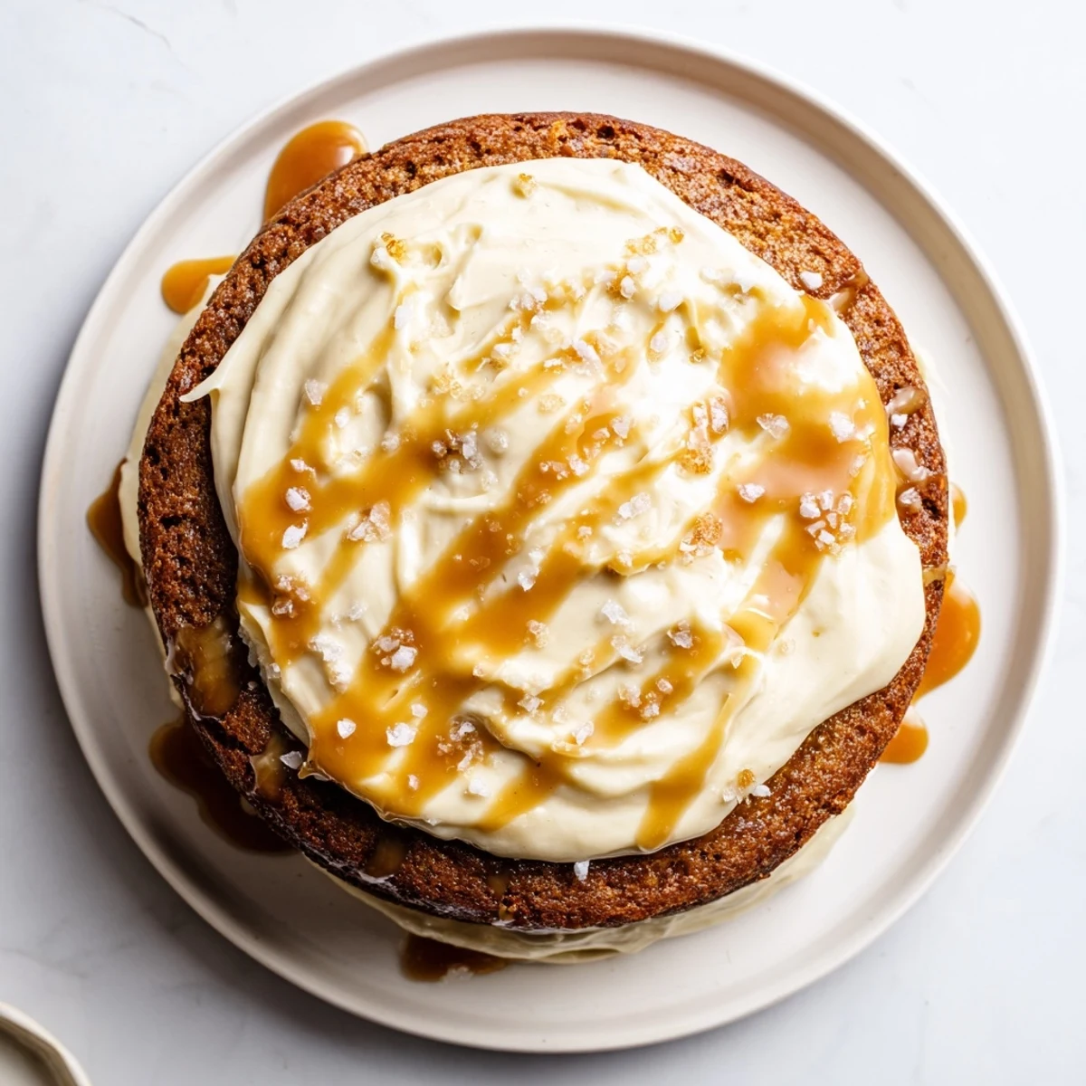 Decadent salted caramel brown butter banana cake slice dripping with glossy amber caramel sauce