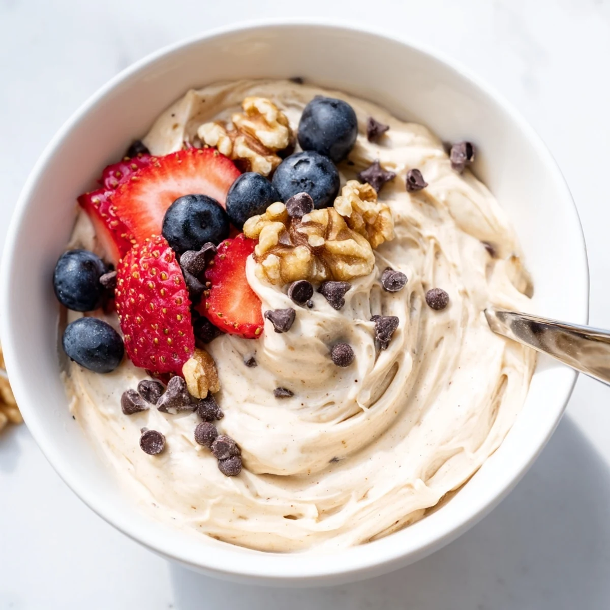 Homemade banana nice cream with swirls of peanut butter and chocolate chip garnish