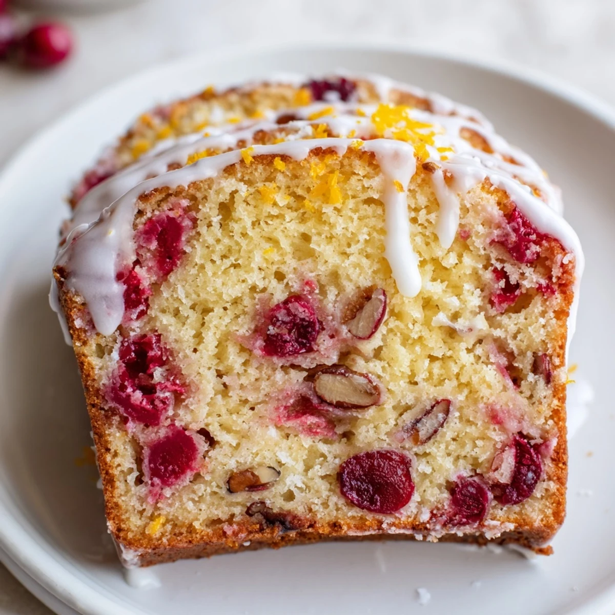 Sliced Cranberry Orange Bread releasing zesty aroma, studded with tart cranberries