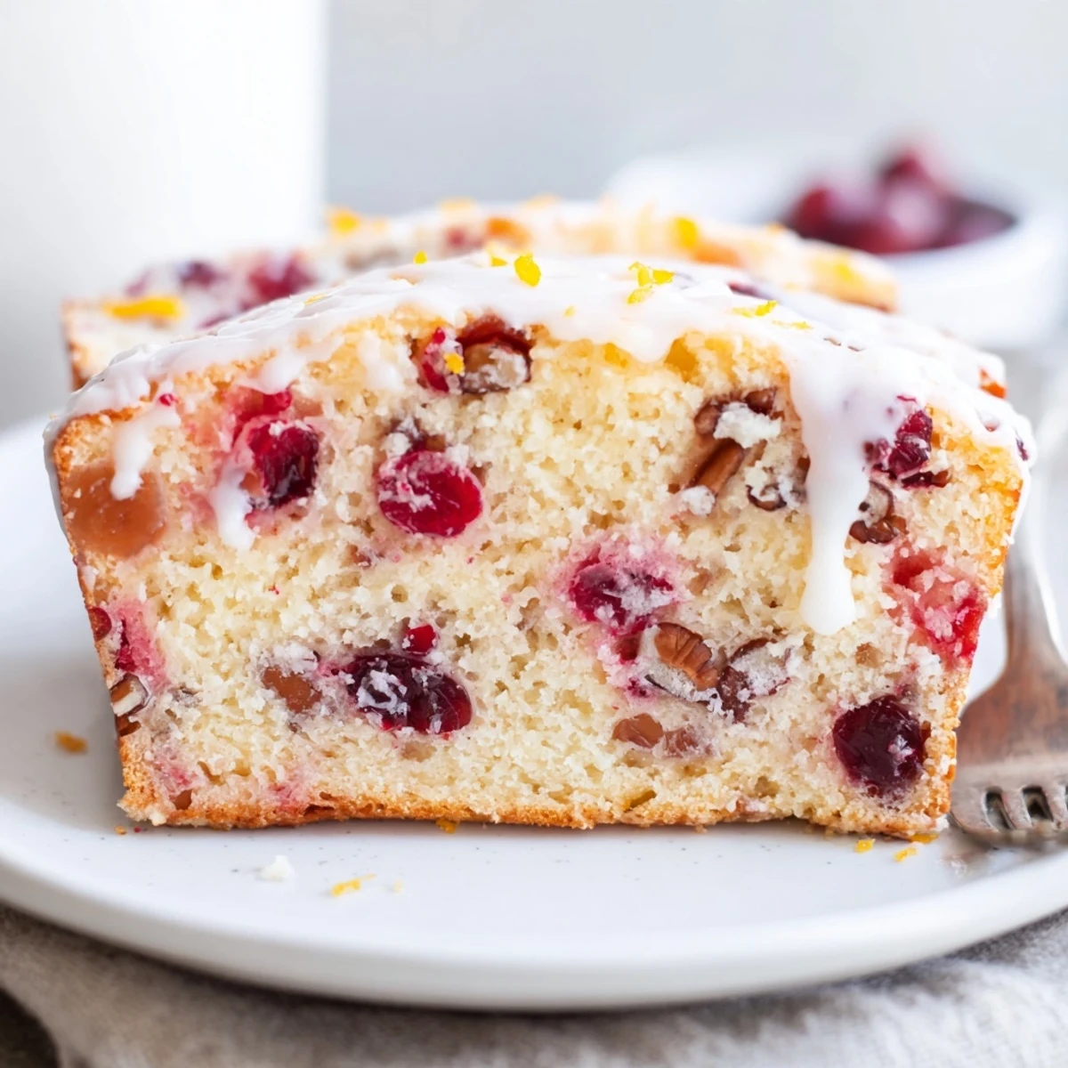 A warm slice of Cranberry Orange Bread served with butter and Earl Grey