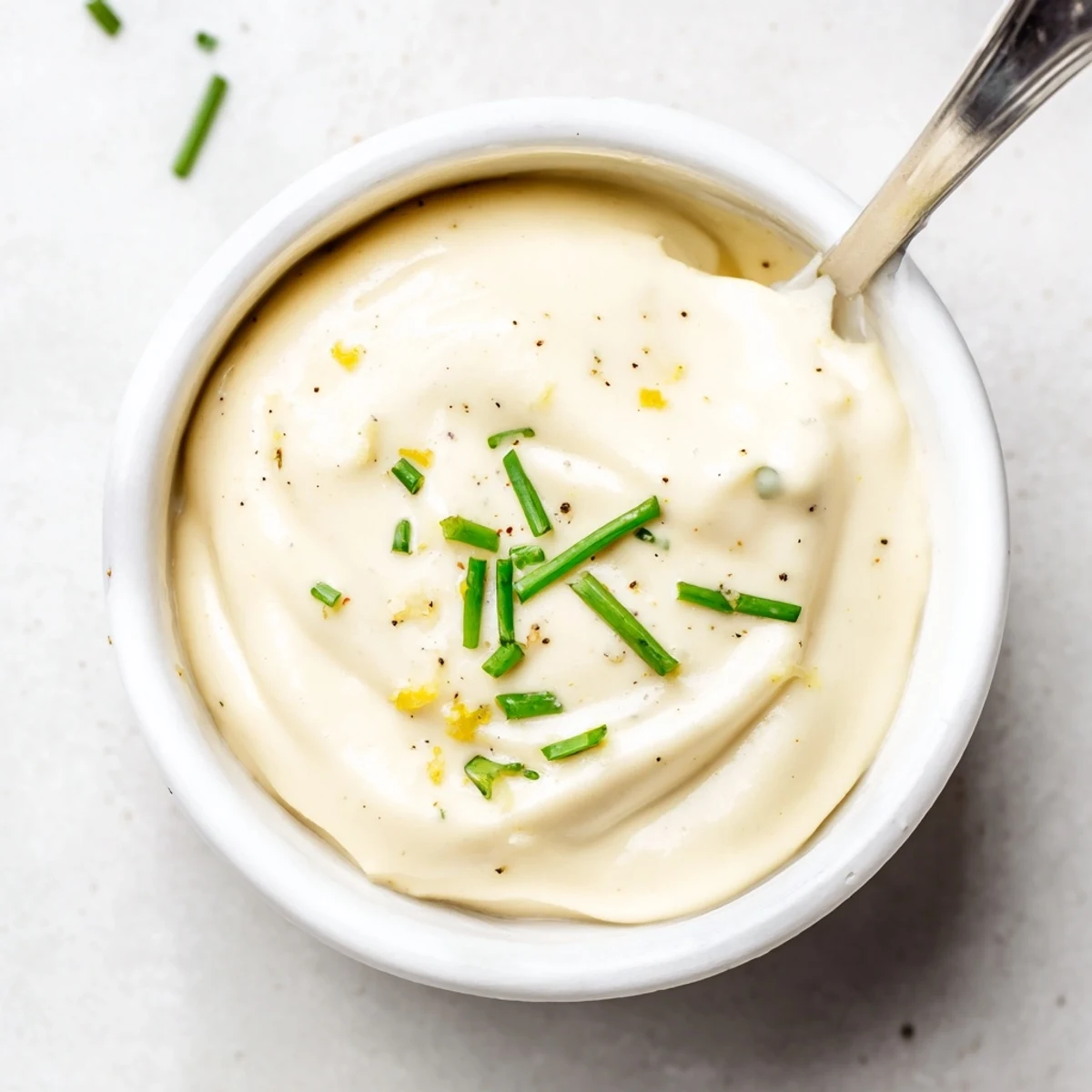 Bowl of Creamy Tangy Sauce with herbs, perfect for dipping roasted veggies