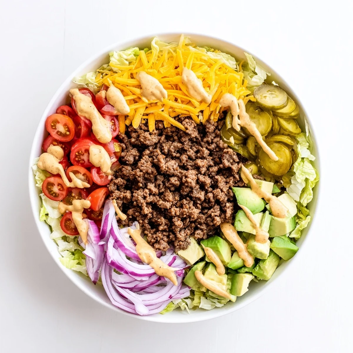Savory deconstructed burger bowl with juicy ground turkey, crunchy toppings, melted cheddar, and zesty yogurt sauce ready to serve