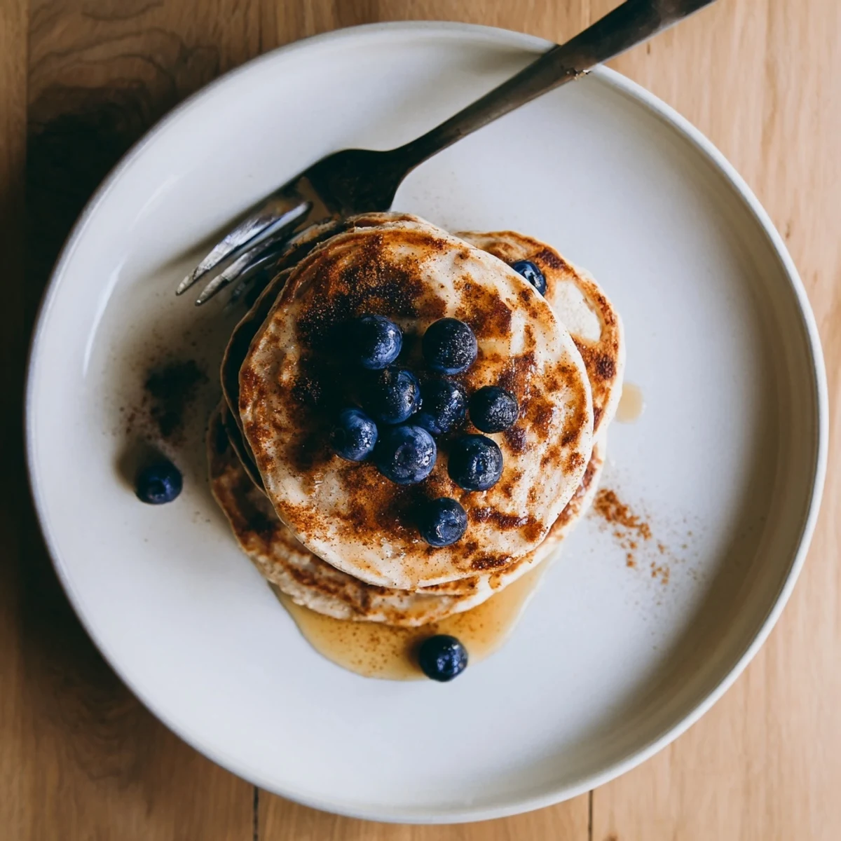 Golden brown protein banana pancakes cooking on a skillet with visible surface bubbles