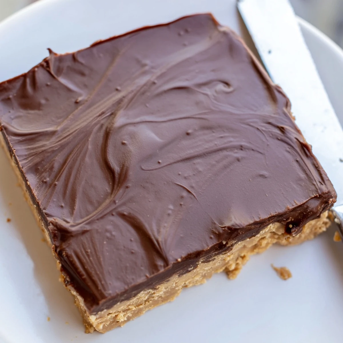No-bake peanut butter bars featuring smooth peanut butter layer topped with melted semisweet chocolate