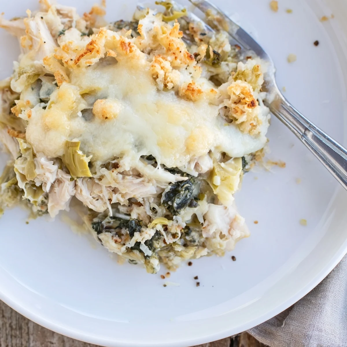 Bubbly spinach artichoke chicken casserole with golden breadcrumb crust, served hot