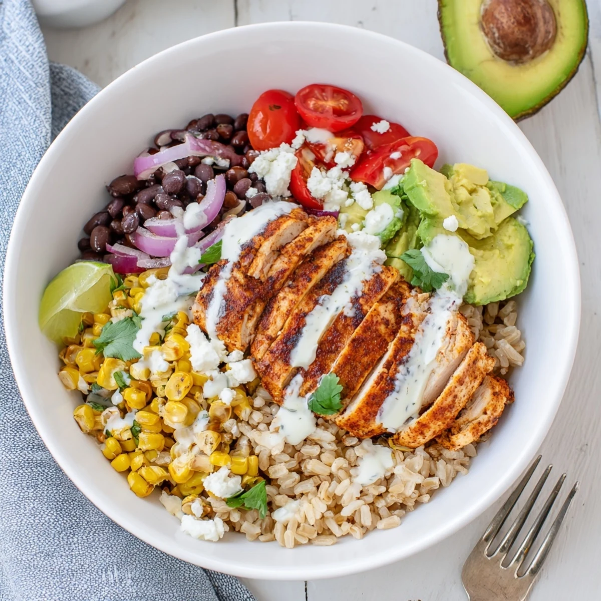 Colorful healthy street corn chicken bowl served over quinoa with juicy sliced chicken