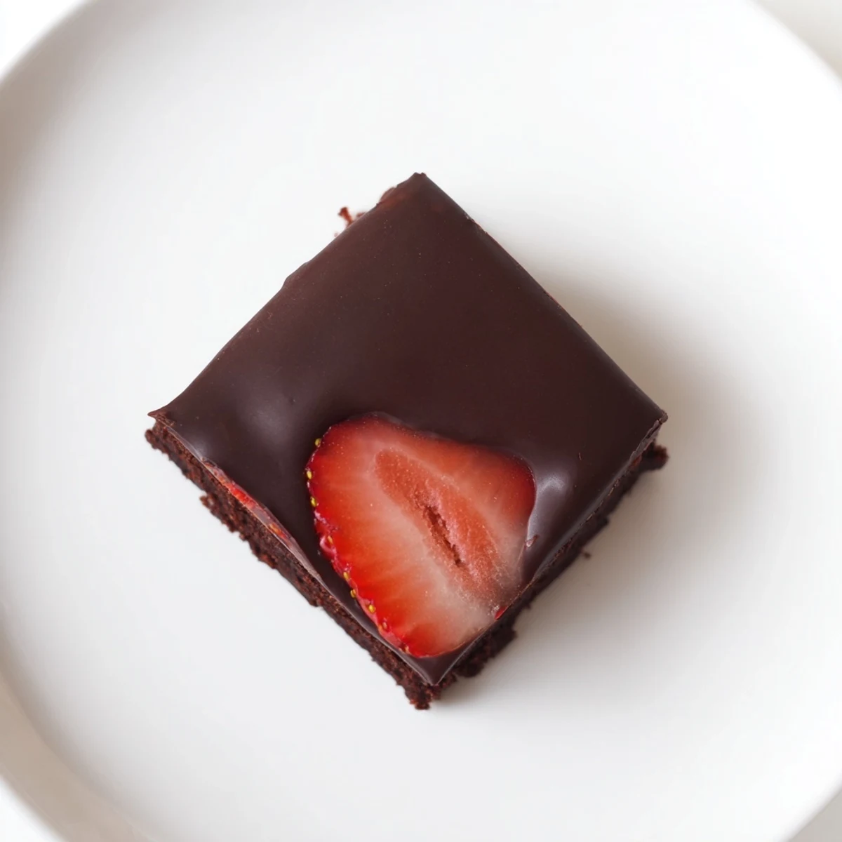 Fudgy chocolate covered strawberry brownies sliced into rich, decadent squares on a rustic cutting board