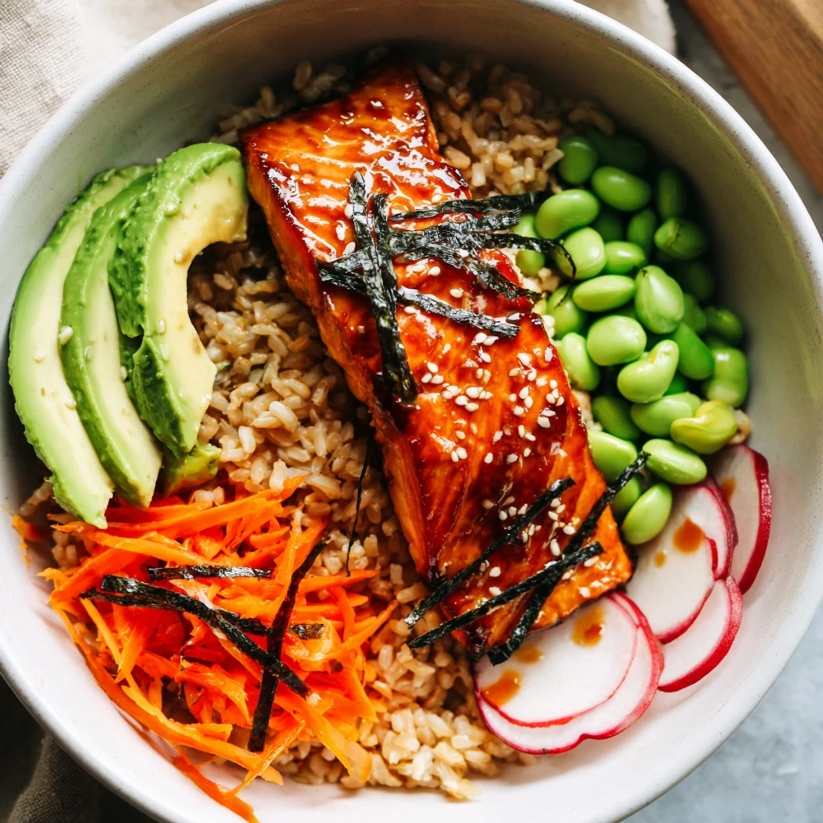 Steaming miso salmon grain bowl with colorful fresh vegetables drizzled in tangy rice dressing