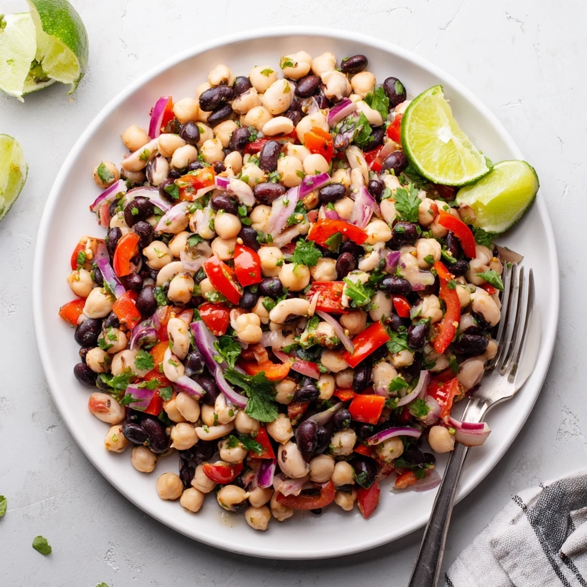 Fresh cilantro lime bean salad featuring three types of beans tossed with zesty lime dressing and vibrant vegetables