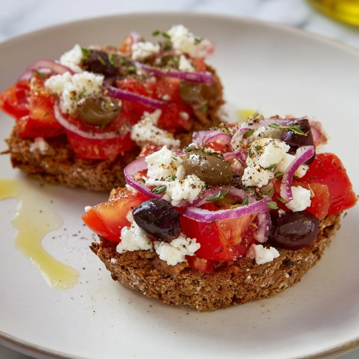 Golden crispy Cretan feta rusks topped with ripe tomatoes, olives, and fragrant oregano