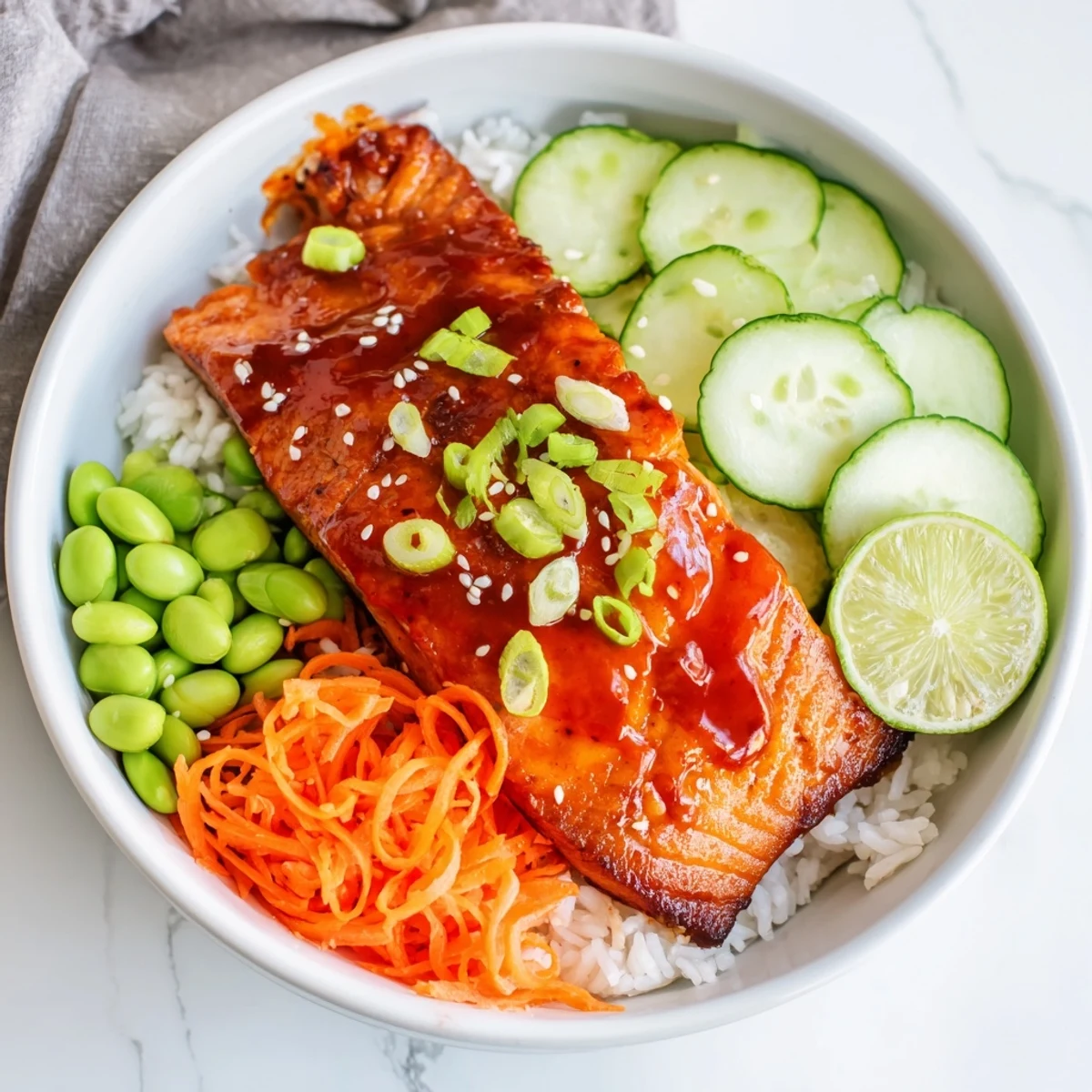 Glossy sriracha honey glazed salmon fillets over steamed rice with fresh crisp vegetables