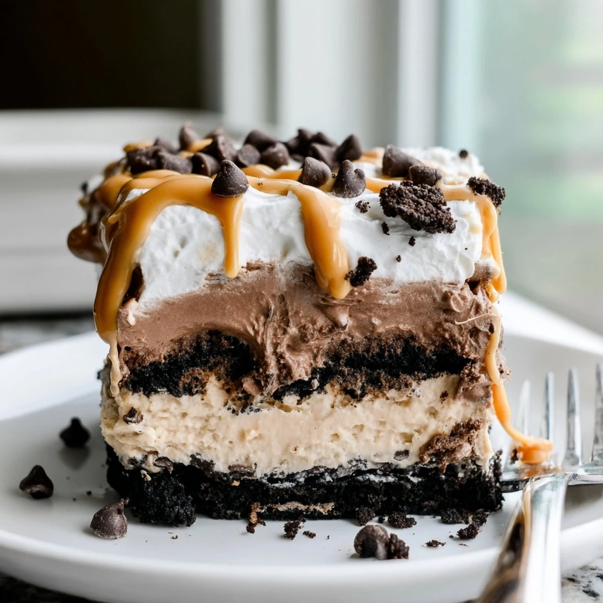 Peanut butter layered delight sliced into squares topped with whipped cream drizzle