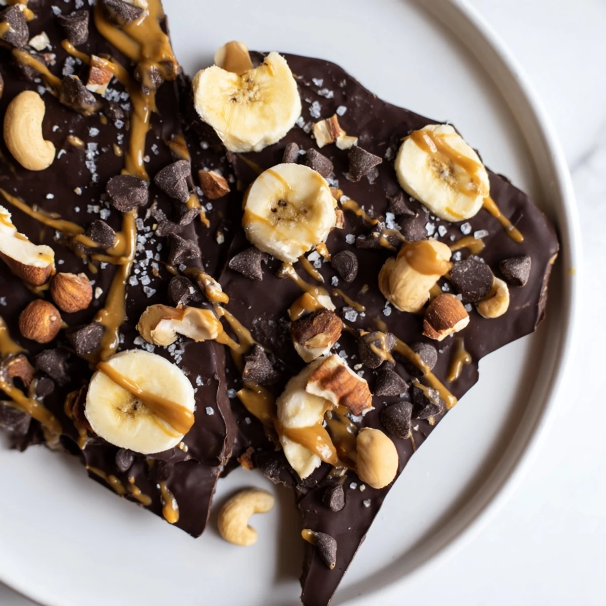 Chilled chocolate banana bark with a drizzle of peanut butter and crunchy peanuts