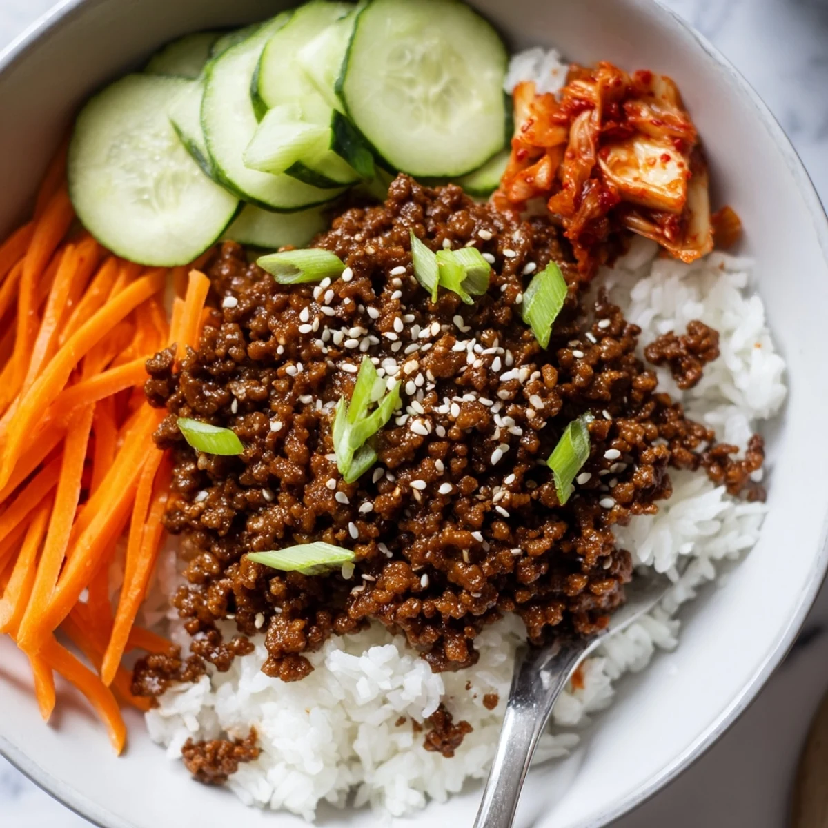 Savory Korean ground beef bowl glistening with spicy-sweet sauce over fluffy white rice