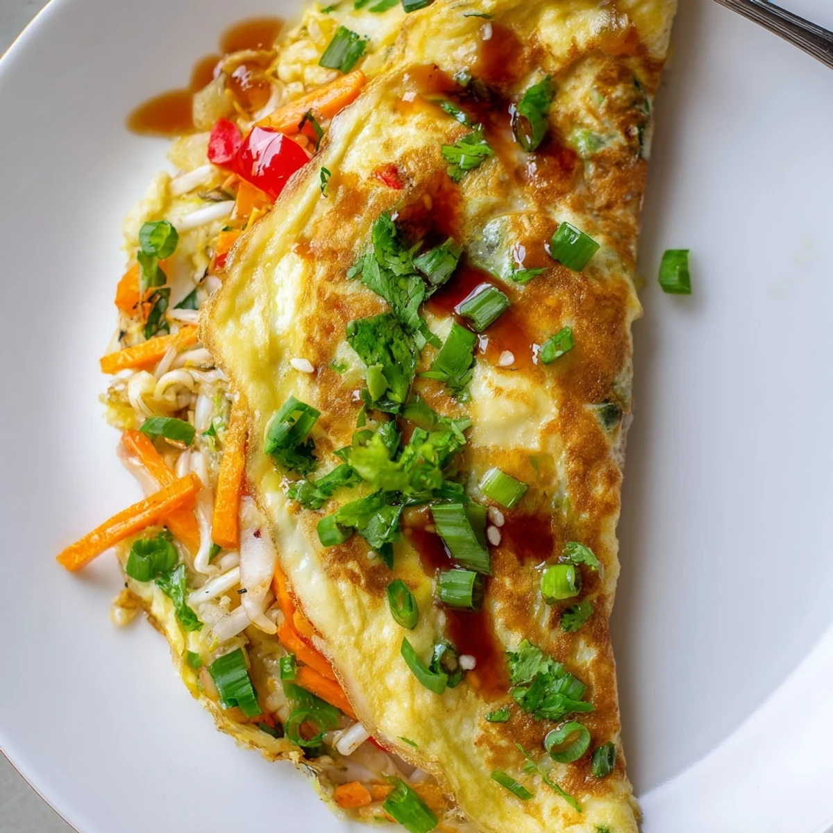 Golden Chinese omelette folded over crisp vegetables and topped with fresh scallions