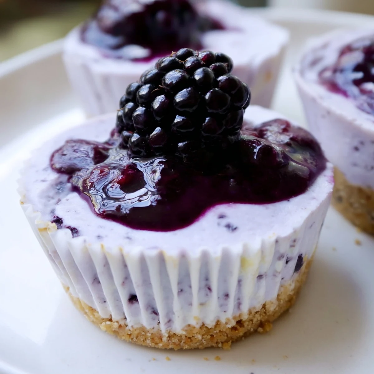 Creamy no bake mini blackberry lavender cheesecakes piped high with fresh berry garnish