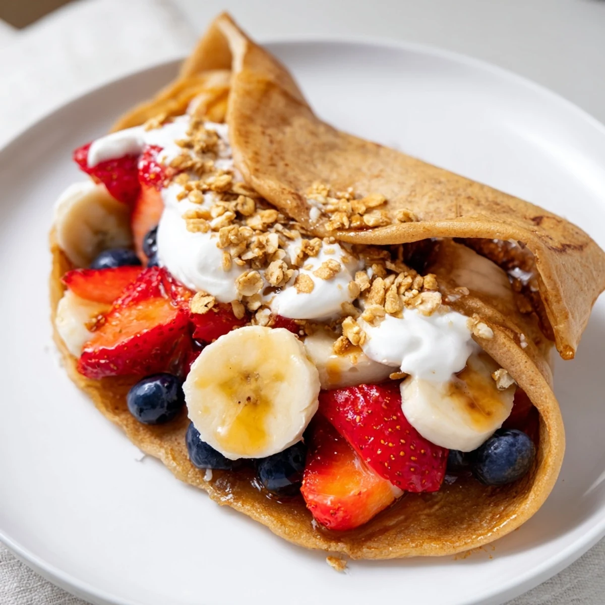 Golden fluffy pancake tacos filled with fresh strawberries and drizzled maple syrup