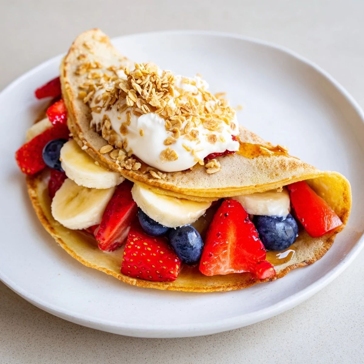 Warm pancake tacos folded around Greek yogurt blueberries and crunchy granola