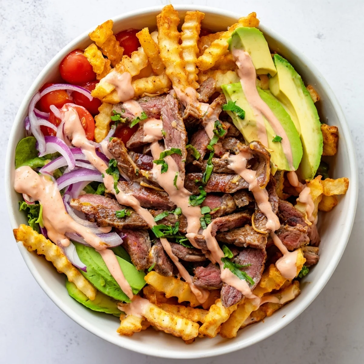 Crusty seared steak strips crispy fries bowl drizzled with smoky paprika sauce