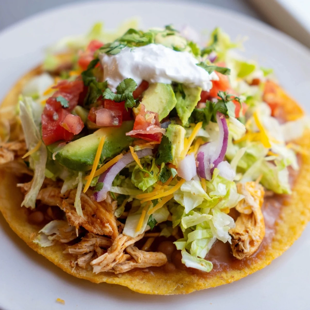 Delicious Chicken Tostadas piled high with juicy meat, cheese, and zesty lime.