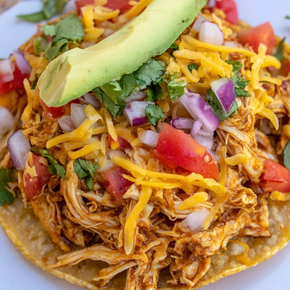 Golden Chicken Tostadas loaded with shredded meat, veggies, and zesty lime wedges.
