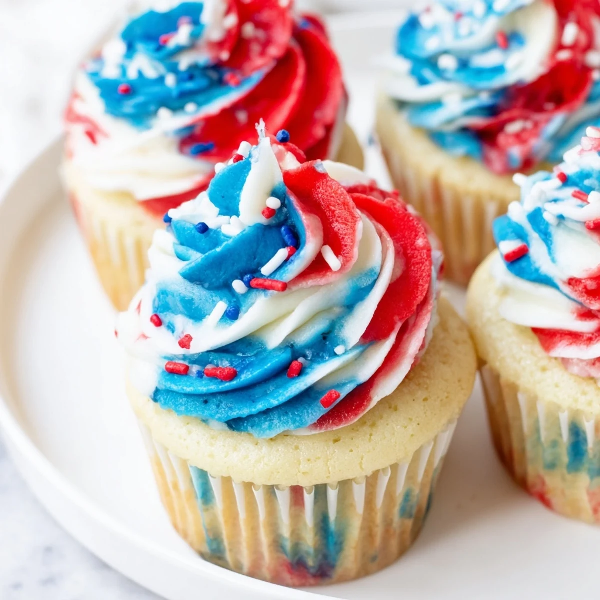 Moist vanilla July tie dye cupcakes topped with vibrant patriotic colored frosting.  