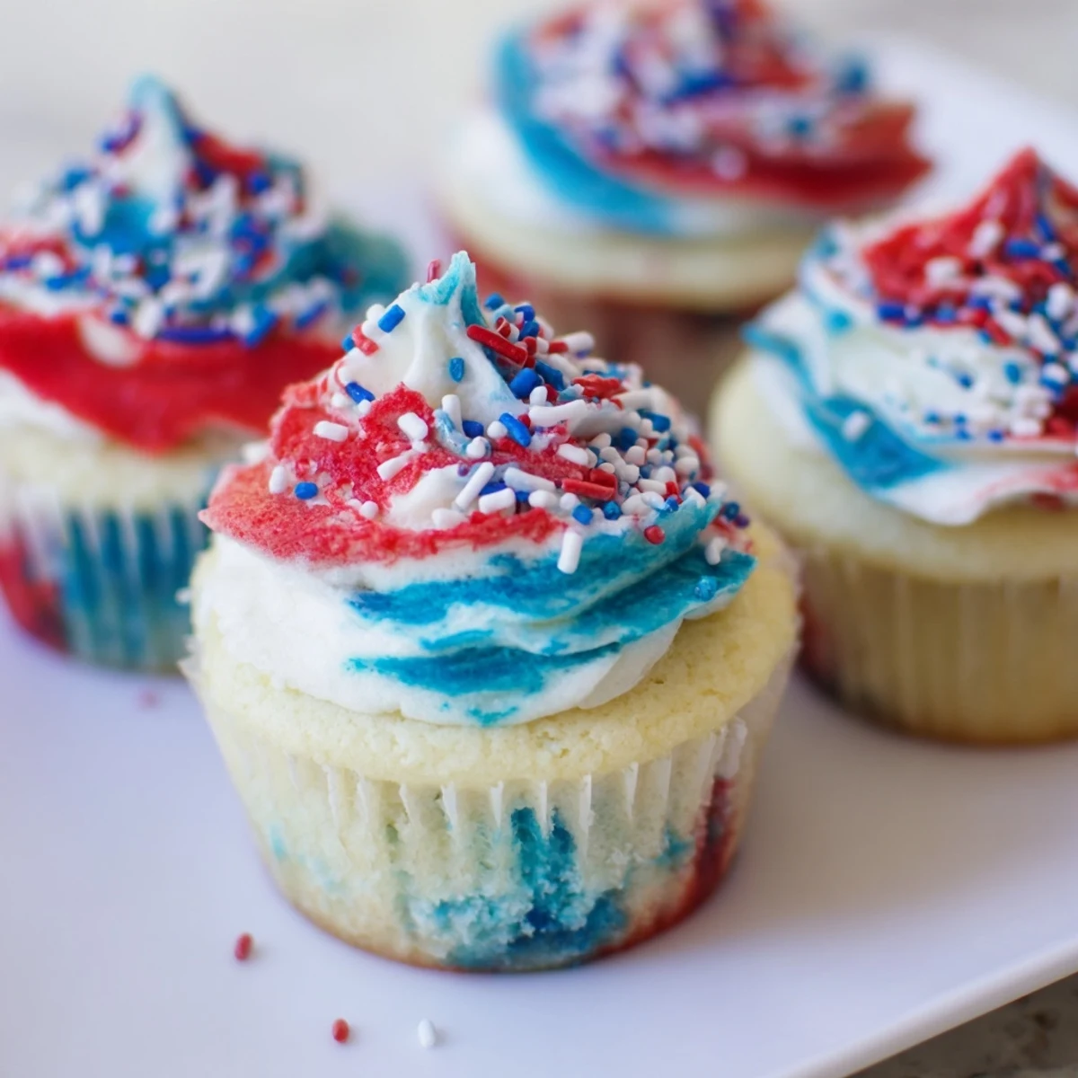 Colorful July tie dye cupcakes with red, white, and blue swirls for celebrations.
