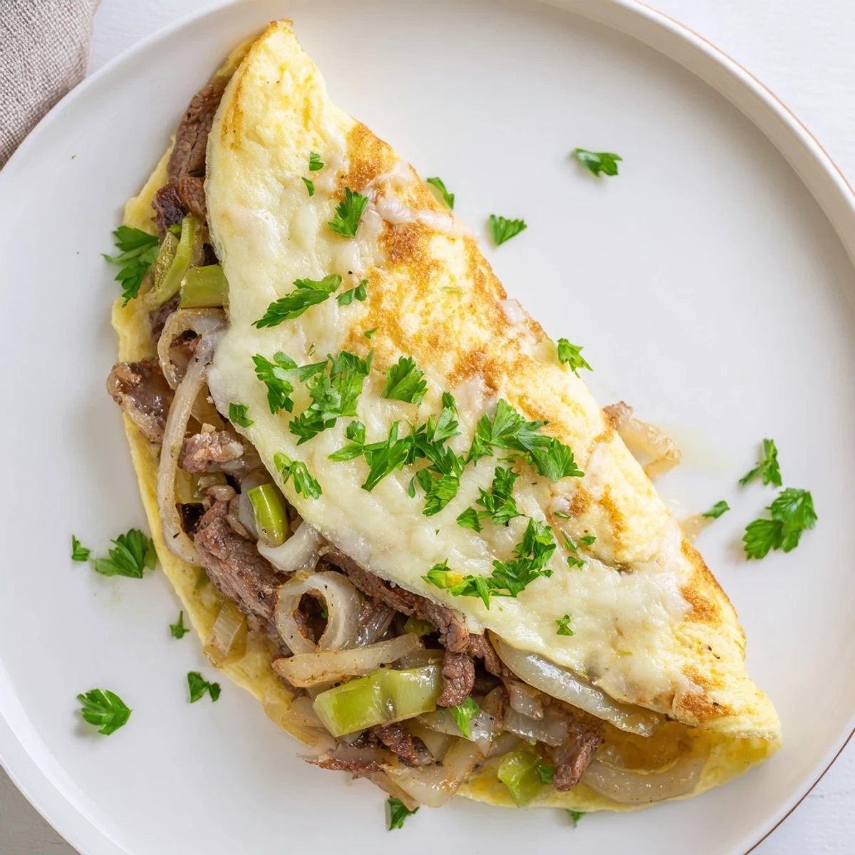 Fluffy omelette filled with sautéed beef, onions, and gooey provolone for breakfast.  