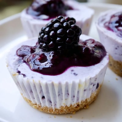 Creamy no bake mini blackberry lavender cheesecakes piped high with fresh berry garnish